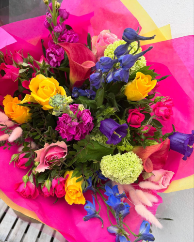 Colour burst - A dazzling burst of bold colour, this bouquet features a lively mix of seasonal flowers arranged with soft greenery.